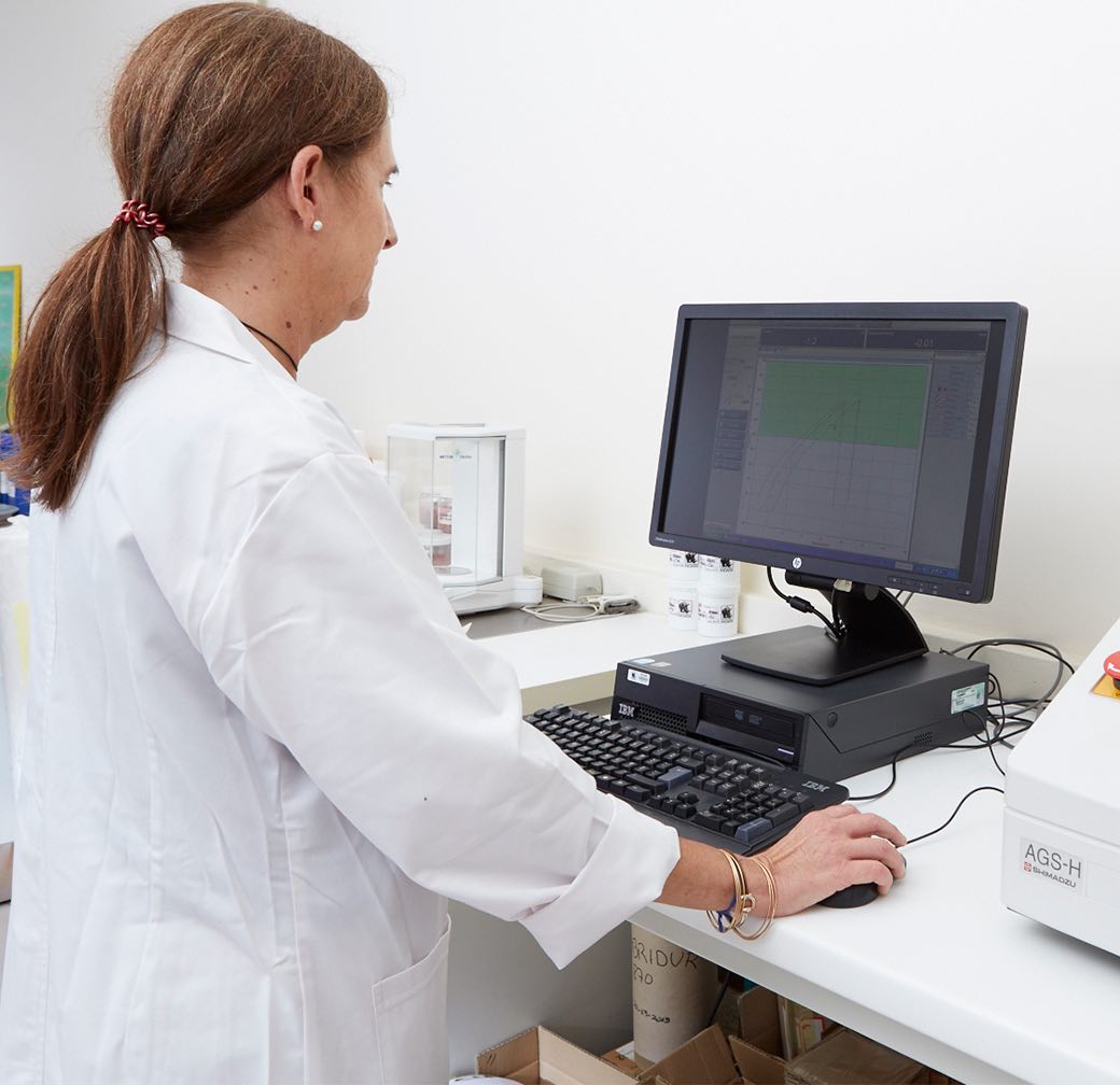 mulher com bata branca em laboratório com computador