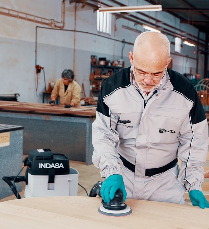 hombre lijando una mesa de madera con la lijadora E-Series INDASA